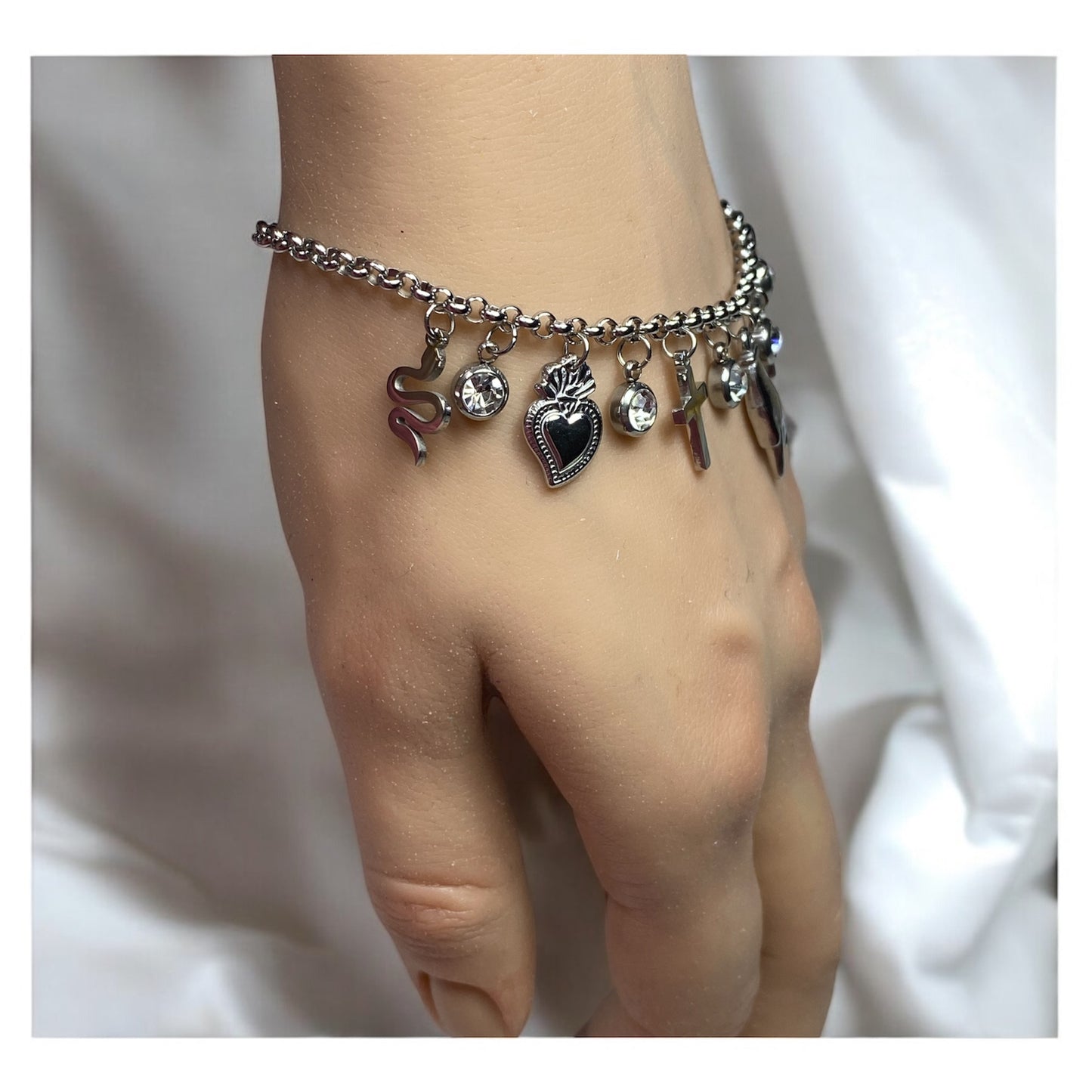 Bracciale con charm in acciaio- cuore-croce-corna-serpente-zirconi